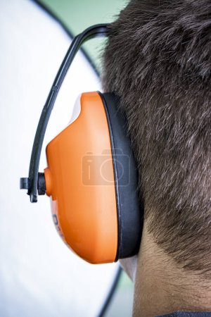 Man wearing noise canceling headphones, hearing protection.