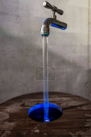 Téléchargez les photos : Fontaine de robinet magique, illusion optique d'eau courante. Image verticale de haute qualité - en image libre de droit