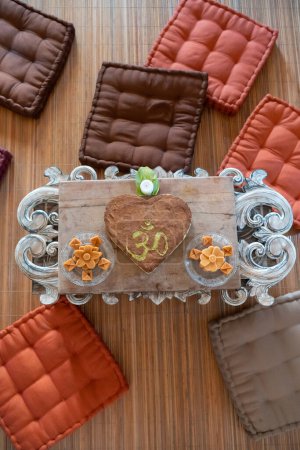 Photo for Healthy raw heart-shaped om cake on a coffee table - Royalty Free Image