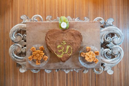 Photo for Healthy raw heart-shaped om cake on a coffee table - Royalty Free Image