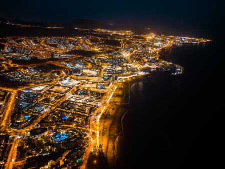 Foto de Hermosa vista aérea del dron de la ciudad o ciudad iluminada de la noche con la orilla del océano y las luces, Tenerife, isla canaria, atardecer, crepúsculo. Foto de alta calidad - Imagen libre de derechos