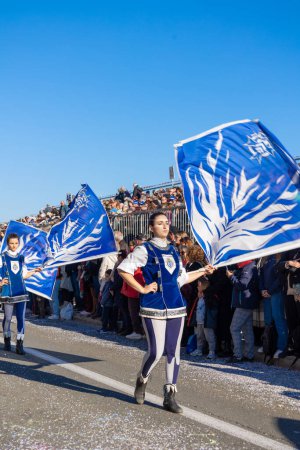 Téléchargez les photos : Menton, France-12 février 2023 : Les porteurs du drapeau de la fanfare en uniformes bleus dynamiques se produisent lors d'un défilé de rue lors du traditionnel défilé de carnaval du Festival du citron. - en image libre de droit