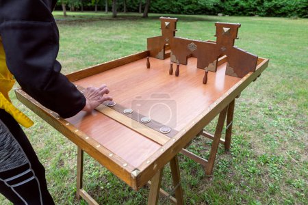 De cerca la mano jugando un juego de mesa de madera vintage al aire libre en el parque público. 