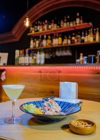 Photo for Peruvian ceviche served on a blue plate, accompanied by Pisco and toasted corn - Royalty Free Image