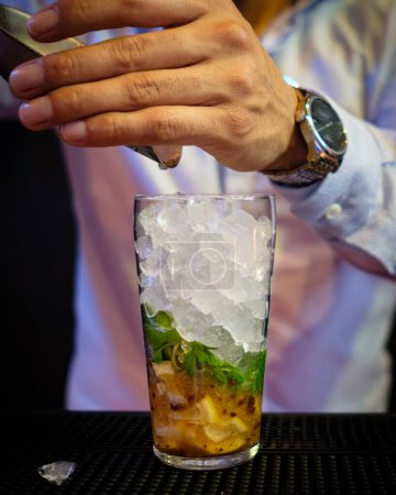 Photo for Preparation of a cocktail based on lemon, pisco liqueur, fresh mint and cinnamon sugar - Royalty Free Image