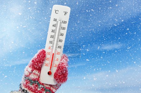Foto de White celsius and fahrenheit scale thermometer in hand. Ambient temperature minus 6 degrees celsius - Imagen libre de derechos