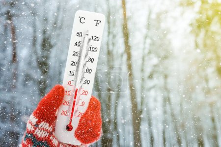 Foto de Termómetro blanco celsius y fahrenheit en mano. Temperatura ambiente menos 2 grados centígrados - Imagen libre de derechos