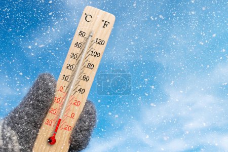 Holztemperatur und Fahrenheit-Thermometer in der Hand. Umgebungstemperatur minus 22 Grad Celsius