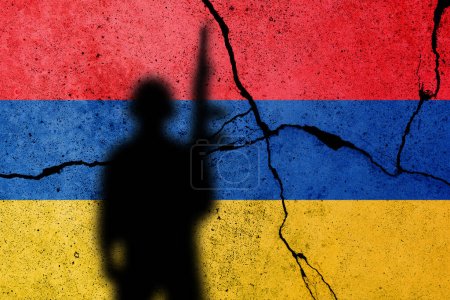 Foto de Armenia y Azerbaiyán entran en conflicto en Nagorno Karabaj. Bandera armenia en el muro de hormigón agrietado con soldado - Imagen libre de derechos