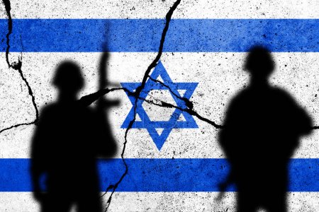 An die Betonmauer gemalte israelische Flaggen mit dem Schatten der Soldaten. Gaza, Hamas und Israel-Konflikt