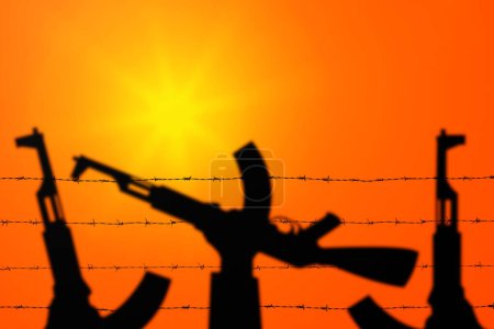 Photo for Hands holding guns over barbed wire. Terrorist organizations hezbollah and hamas. - Royalty Free Image