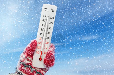 Téléchargez les photos : Thermomètre blanc Celsius et échelle fahrenheit à la main. Température ambiante moins 24 degrés Celsius - en image libre de droit