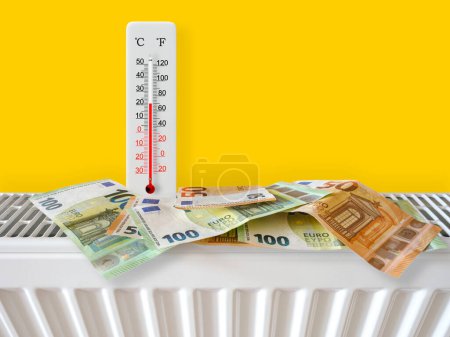 Euro-Banknoten am Heizkörper mit Thermometer. Energiekrise und teure Heizkosten für den Winter. Große Heizungs- und Gasrechnung. Thermometer zeigt plus 21 Grad warm