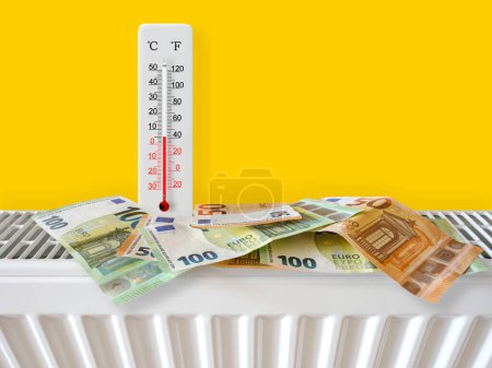 Euro-Banknoten am Heizkörper mit Thermometer. Energiekrise und teure Heizkosten für den Winter. Große Heizungs- und Gasrechnung. Thermometer zeigt plus 5 Grad warm