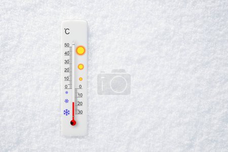 White celsius scale thermometer in snow. Ambient temperature minus 16 degrees celsius