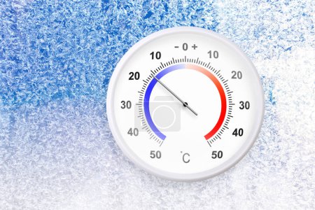 Celsius scale thermometer on a frozen window shows minus 16 degrees 