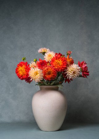 A large bouquet of bright dahlias in a large vase. Autumn still life. Copy space.
