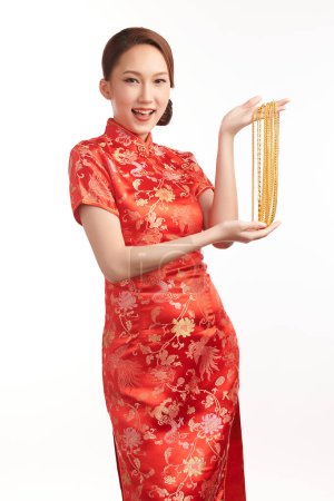 Foto de Festival de año nuevo chino, Hermosa mujer asiática joven con cheongsam tradicional vestido qipao con collares de oro sobre fondo blanco, - Imagen libre de derechos