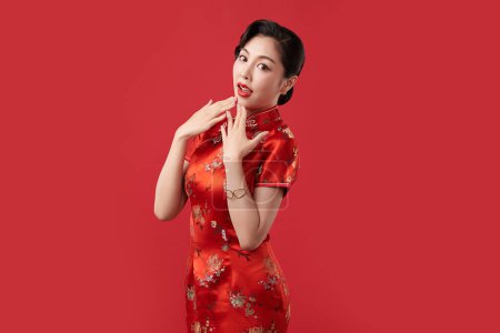 Téléchargez les photos : Asian chinese woman in traditional cheongsam qipao dress on red background. Chinese new year festival, - en image libre de droit