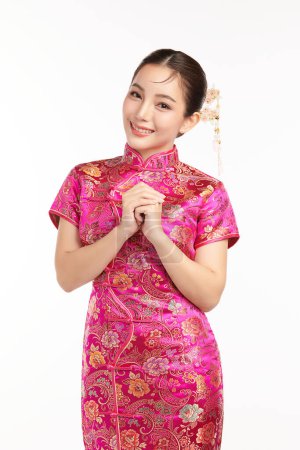 Foto de Feliz año nuevo chino, Hermosa mujer asiática joven con cheongsam tradicional vestido qipao con gesto de felicitación aislado sobre fondo blanco. - Imagen libre de derechos