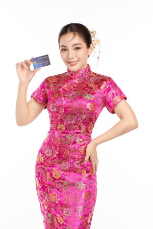 Photo for Happy Chinese new year, Beautiful young Asian woman wearing traditional cheongsam qipao dress holding credit card on red background, - Royalty Free Image