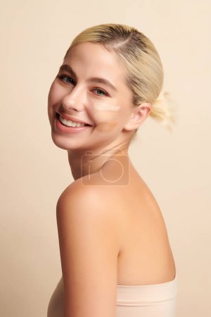 Photo for Beautiful smiling woman with tone cream lines on her face, girl with perfect makeup on white background, Skin care concept. - Royalty Free Image