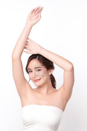 Foto de Hermosa mujer asiática joven levantando las manos para mostrar las axilas limpias e higiénicas o axilas sobre fondo blanco, limpieza suave de axilas y concepto de protección - Imagen libre de derechos