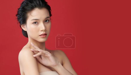 Foto de Hermosa mujer asiática joven con piel limpia y fresca sobre fondo rojo, Cuidado de la cara, Tratamiento facial, Cosmetología, belleza y spa, Retrato de mujeres asiáticas. - Imagen libre de derechos