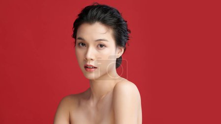 Téléchargez les photos : Belle jeune femme asiatique avec une peau propre et fraîche sur fond rouge, Soins du visage, Soins du visage, Cosmétologie, beauté et spa, Portrait de femmes asiatiques. - en image libre de droit