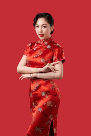Téléchargez les photos : Femme chinoise asiatique en robe traditionnelle sur fond rouge. Nouvel an chinois festival - en image libre de droit