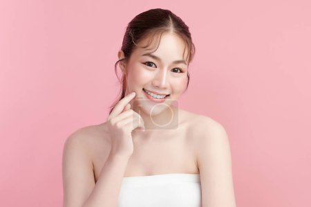 Foto de Hermosa mujer asiática joven con piel limpia y fresca sobre fondo rosa, Cuidado de la cara, Tratamiento facial, Cosmetología, belleza y spa, Retrato de mujeres asiáticas. - Imagen libre de derechos