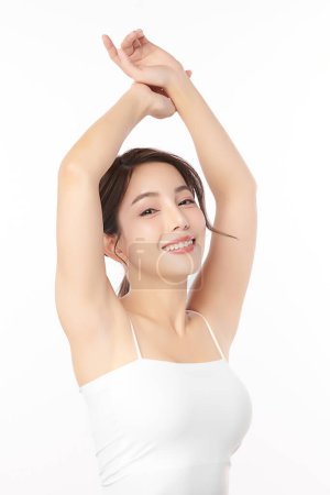 Téléchargez les photos : Belle jeune femme asiatique levant les mains pour montrer des aisselles ou aisselles propres et hygiéniques sur fond blanc, concept de propreté et de protection des aisselles lisses - en image libre de droit