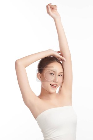 Téléchargez les photos : Belle jeune femme asiatique levant les mains pour montrer des aisselles ou aisselles propres et hygiéniques sur fond blanc, concept de propreté et de protection des aisselles lisses - en image libre de droit