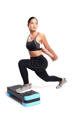 Photo for An asian woman is  working out  wearing the sport exercise suit with white background. - Royalty Free Image