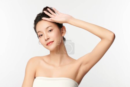 Foto de Hermosa mujer asiática joven levantando las manos para mostrar las axilas limpias e higiénicas o axilas sobre fondo blanco, limpieza suave de axilas y concepto de protección - Imagen libre de derechos