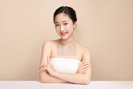 Foto de Hermosa mujer asiática joven con piel limpia y fresca sobre fondo beige, Cuidado de la cara, Tratamiento facial, Cosmetología, belleza y spa, Retrato de mujeres asiáticas. - Imagen libre de derechos
