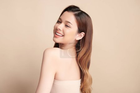 Téléchargez les photos : Beau sourire de jeune femme asiatique avec des dents blanches saines sur fond beige, Soins dentaires. Concept de dentisterie. - en image libre de droit