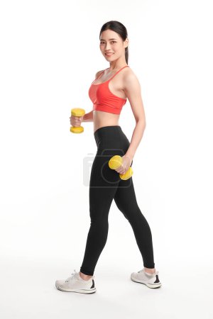 Foto de Mujer deportiva hace los ejercicios con pesas sobre fondo blanco, fuerza y motivación. - Imagen libre de derechos