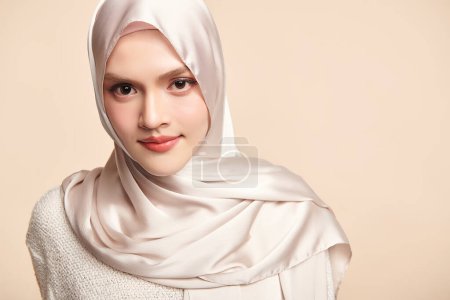 Téléchargez les photos : Belle jeune femme musulmane asiatique portant un hijab blanc sur fond beige, Portrait de Beauté Arabe. - en image libre de droit