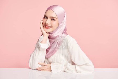 Photo for Beautiful young asian muslim woman wearing a pink hijab on pink background, Portrait of Arab Beauty. - Royalty Free Image