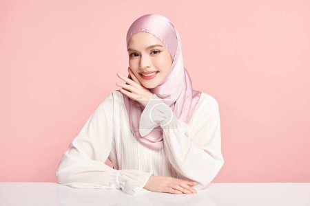 Foto de Hermosa joven mujer musulmana asiática usando un hiyab rosa sobre fondo rosa, Retrato de belleza árabe. - Imagen libre de derechos