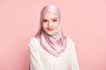 Téléchargez les photos : Belle jeune femme musulmane asiatique portant un hijab rose sur fond rose, Portrait de Beauté Arabe. - en image libre de droit