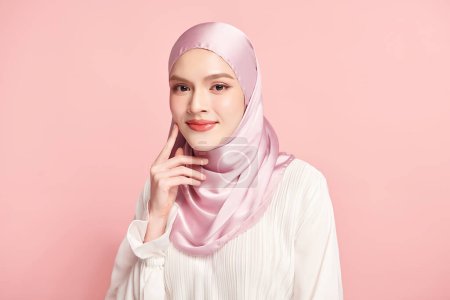Téléchargez les photos : Belle jeune femme musulmane asiatique portant un hijab rose sur fond rose, Portrait de Beauté Arabe. - en image libre de droit