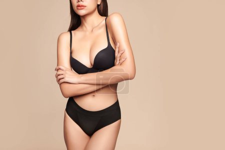 Téléchargez les photos : Confiant belle jeune femme asiatique posant en lingerie noire sur fond beige, corps parfait, - en image libre de droit