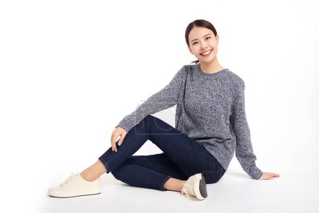 Téléchargez les photos : Belle jeune femme asiatique souriante heureuse et assise sur le sol sur fond blanc, Jeune fille féminine avec un sourire parfait. - en image libre de droit