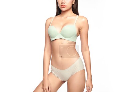 Téléchargez les photos : Confiant belle jeune femme asiatique posant en lingerie vert clair sur fond blanc, corps parfait, - en image libre de droit