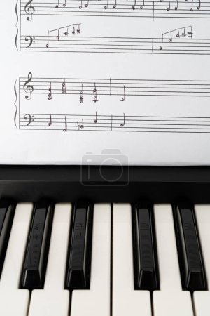 Photo for Musical keyboard and handwritten sheet music in a verticall orientation - Royalty Free Image