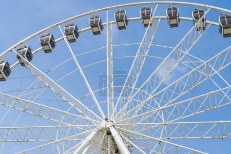 Photo for The gondola's and spokes of a large white Ferris Wheel - Royalty Free Image