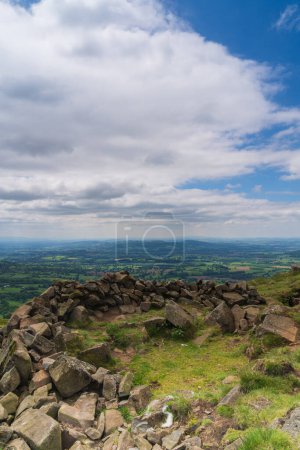 Round shape of boulders at the summit of Titterstone Clee in Shropshire, UK in  portrait orientation