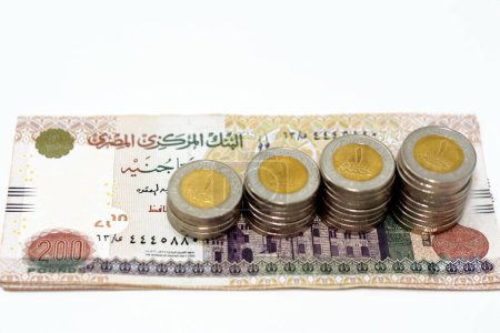 Photo for Pile of 200 EGP LE two hundred Egyptian pounds money banknotes with stacks of 1 LE EGP one pound coins isolated on white background, Egypt currency exchange rate concept,  selective focus - Royalty Free Image